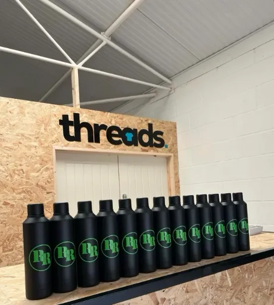 Inside the Threads workshop — printed bottles lined up under the workshop sign