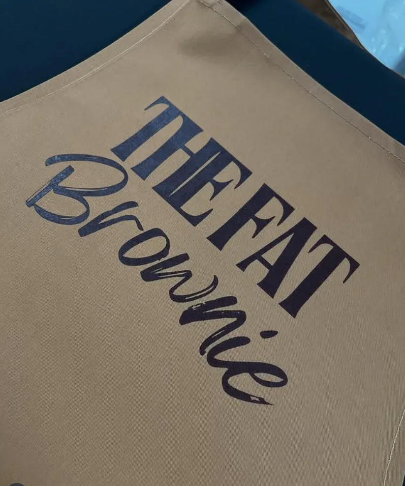 Tan apron printed with The Fat Brownie logo