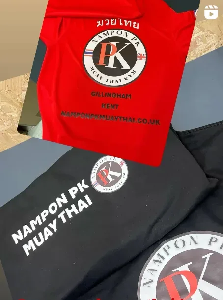Red and black Nampon PK Muay Thai Gym shirts with Thai script