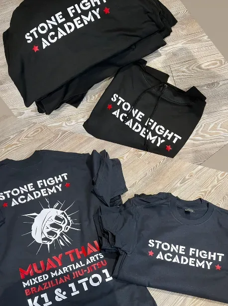 Stone Fight Academy printed tees and hoodies folded in a stack
